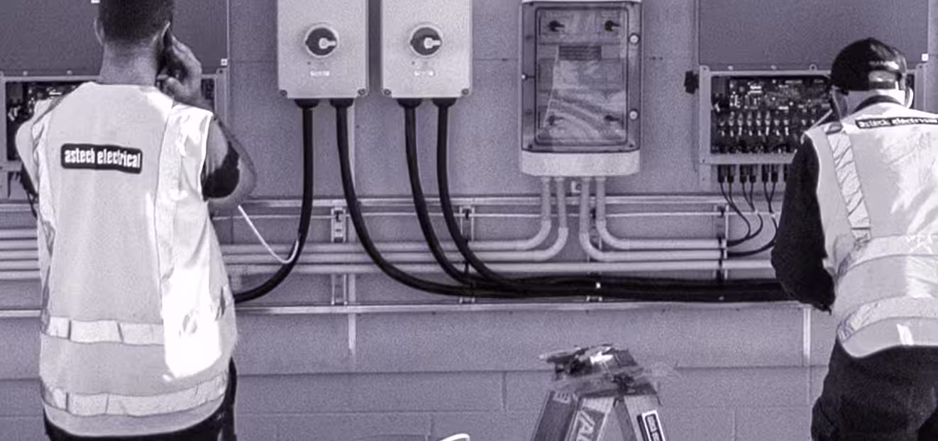 Two electricians inspecting electrical equipment